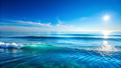 Obraz premium A tranquil seascape with gentle waves lapping against the shore, illuminated by the warm glow of the sun peeking through a clear blue sky.