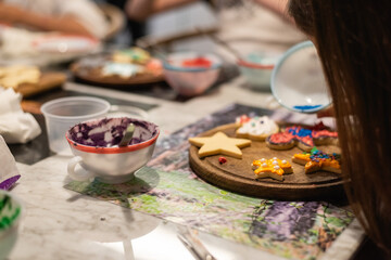 Hands of a child decorating a cookie for the holidays