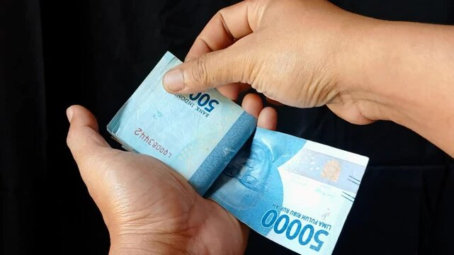 Recording counting 50 thousand Indonesian rupiah notes. Counting Indonesian rupiah banknotes.