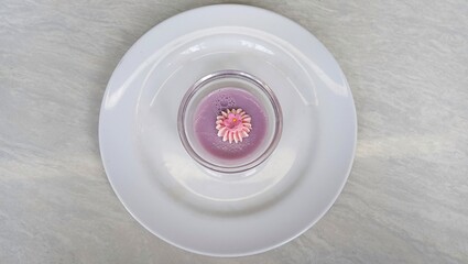 Mini purple pudding in a small bowl with a little cream and flower icing. Elegant dessert at the hotel. hotel breakfast menu. top of view.