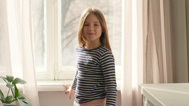 Happy Caucasian little girl child daughter kid pupil approaching toothy dental smile learner preschool schoolgirl home weekend holidays female baby offspring childhood laughter vacation pleasure face