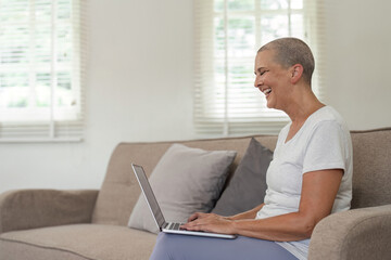 Elderly Woman Relaxing on Couch and Exploring Social Media on Laptop in Modern Home Setting