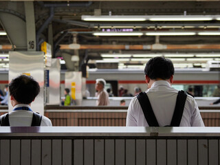 名古屋駅のホームで電車待ちの若い男性と人々の姿