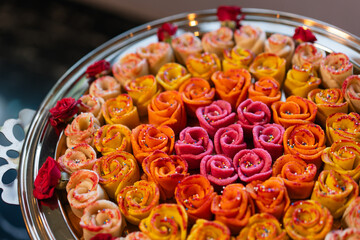 Balushahi, a traditional Indian dessert, crafted in rose shapes and presented in different colors.