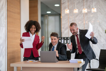 Diverse business team celebrating success at office desk, Concept of teamwork