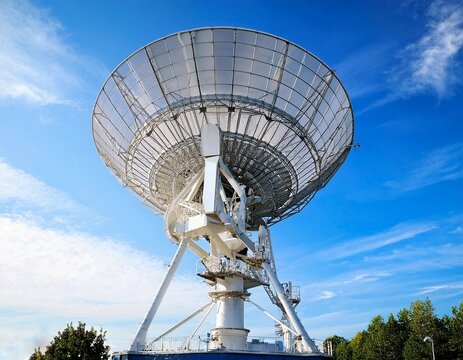 Earth based astronomical radio telescope. Radio telescopes used in science for space observation and distant objects exploring. Radio telescope pointing to the sky with clear blue sky background 