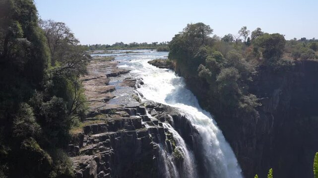 Victoria Falls is a waterfall on the Zambezi River, located on the border between Zambia and Zimbabwe. It is one of the largest waterfalls in the world
