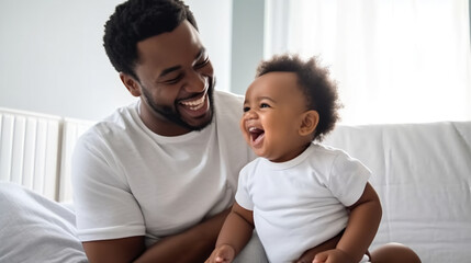 Fototapeta premium A Black father holding his smiling baby boy in a bedroom.