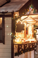 Christmas street market. Wooden houses for selling Christmas decorations and toys. Winter holiday season.