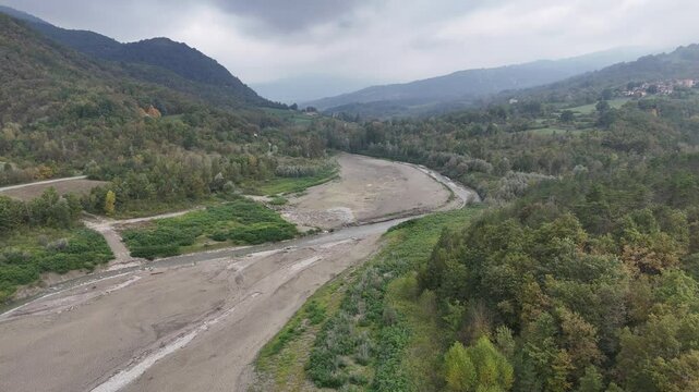 Aerial view of a riverbed almost completely dry during a drought in autumn, concept of global warming. Lago di Mignano, Val Tolla, PC, Italy