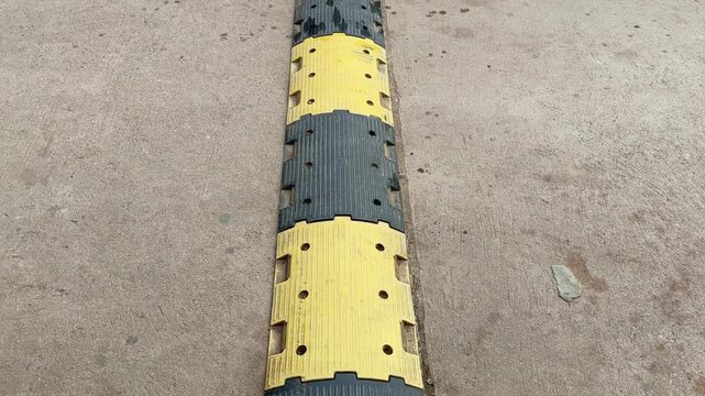 Closeup of Pvc Plastic Speed Breaker Black and yellow used to reduce the speed of vehicle majorly used in school, parking lot