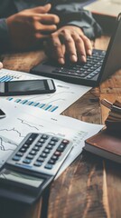 businessman working with finances about cost and calculator and laptop computer on wooden desk in office