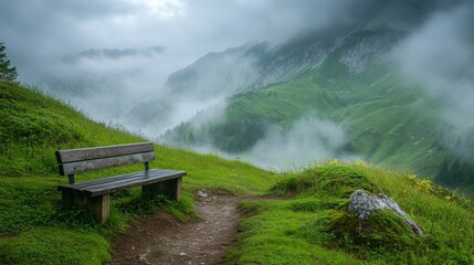 Obraz premium A Wooden Bench Overlooking Fog-Covered Mountain Hills