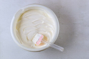 White bowl filled with homemade vanilla frosting cream.