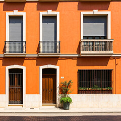Orange brick building with symmetrical windows and doors