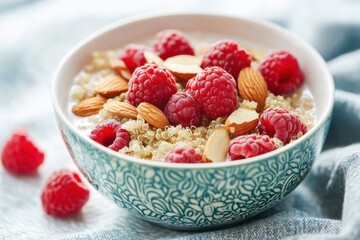 A bowl of quinoa breakfast cereal topped with fresh raspberries, almonds, and a splash of almond milk, representing a nutritious and filling start to the day