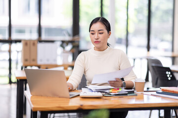 Business financing accounting banking concept. Business woman hand doing finances and calculate on desk about cost at home office. Woman working on desk with using calculator, finance accounting.
