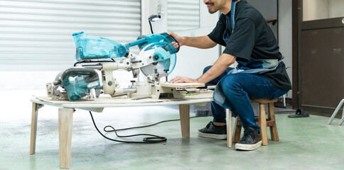 電動ノコギリを使う中年男性