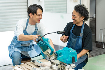 電動ノコギリの使い方を教わる男性