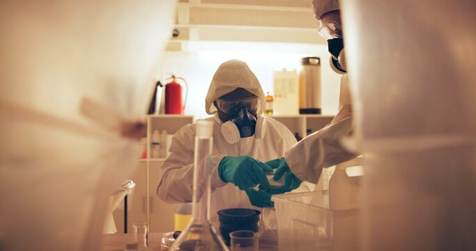 Drugs, people and gas mask in lab for production of illegal substances, narcotics and crystal meth. Basement crime, hazmat suit and powder with compound mixture for cooking cocaine and manufacturing
