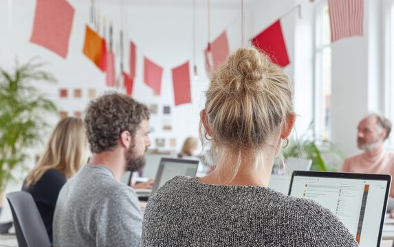 Diverse Team Engaged with Digital Resources in a Modern Office with Cultural Flags