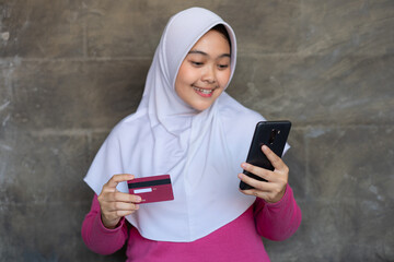 asian hijab women carry credit cards for transactions at home