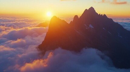 Spectacular sunrise over mangart peak with dramatic views of alpine mountains above the clouds in slovenia, capturing the majestic beauty of a rugged mountain landscape and tranquil dawn colors in a s