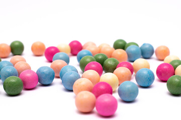 Bunch of colorful candy balls are scattered on a white background