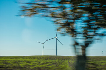 Blurry image of a wind farm with three wind turbines © Lukasz Jasionowski