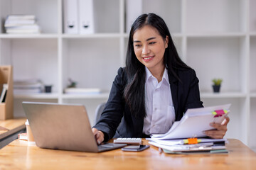 Business asian woman Reviewing Documents, business woman's hands meticulously reviewing a stack of...