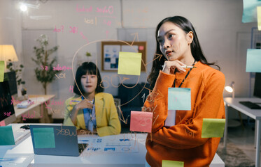 Businesswoman is deep in thought, contemplating ideas and strategies while looking at notes and...