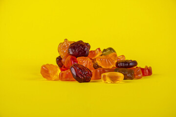 Assorted gummy candies, Juicy colorful jelly sweets. Gummy candies on yellow background
