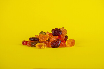 Assorted gummy candies, Juicy colorful jelly sweets. Gummy candies on yellow background