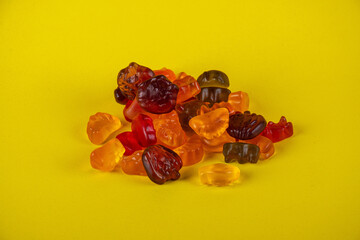 Assorted gummy candies, Juicy colorful jelly sweets. Gummy candies on yellow background