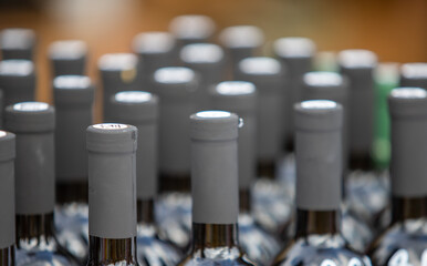 A row of wine bottles with their caps off