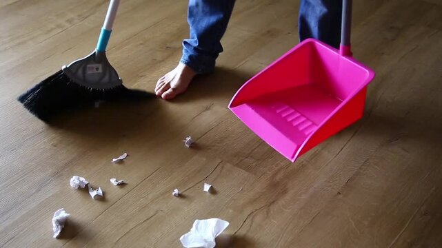 Cleaning.Clean up the garbage from the floor with a broom for cleanliness.Sweep away trash, dust and dirt with a brush into a dustpan