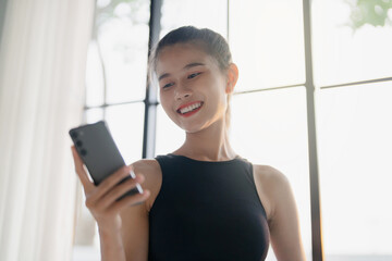 happy woman training at gym holding smartphone