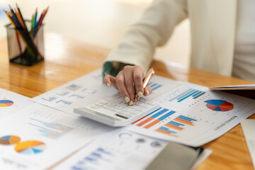 Financial Analyst at Work: Close-up shot of a woman's hands meticulously reviewing financial data,...