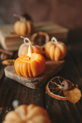 Handmade wax candle in the shape of pumpkins on a dark background