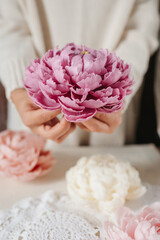 Handmade wax candle in the shape of a pink peony flower