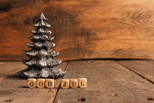 Wooden blocks with the words God Jul, Scandinavian Merry Christmas, Christmas tree shape on a wooden background with space for your text or product