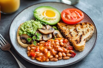 A breakfast plate filled with beans, tomatoes, avocado, and toast