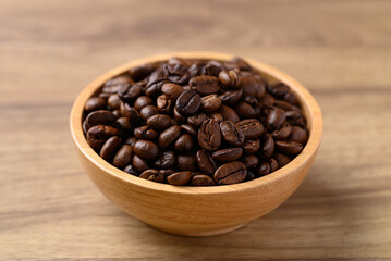 Roasted coffee bean (Arabica coffee) in bowl on wooden background