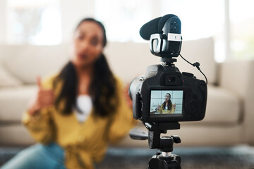 Woman, content creator and thumbs up at apartment with digital camera for podcast, vlogging and recording video. Female person, home and living room as influencer with live screaming and broadcast