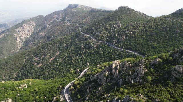 Scenic aerial shot of beautiful windy SS 125 road on top of the mountains in Sardinia.