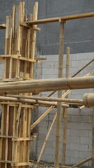 The pillars of a building that are still wrapped in plywood and wood as a mold for the pillars of the building
