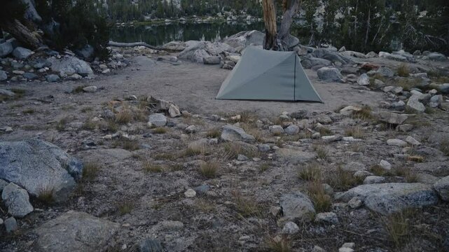 Tent pitched on rocky terrain at Rae Lakes along the John Muir Trail during a serene evening
