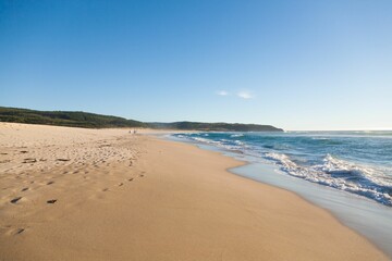 Serene beach landscape with golden sand and gentle waves.