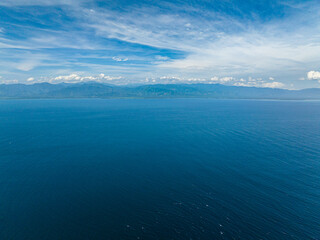 Blue sea with waves and blue sky with cloud, aerial view. Davao, Philippines.