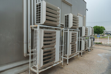 Air compressor or air condenser unit located on support outside building to heat released...